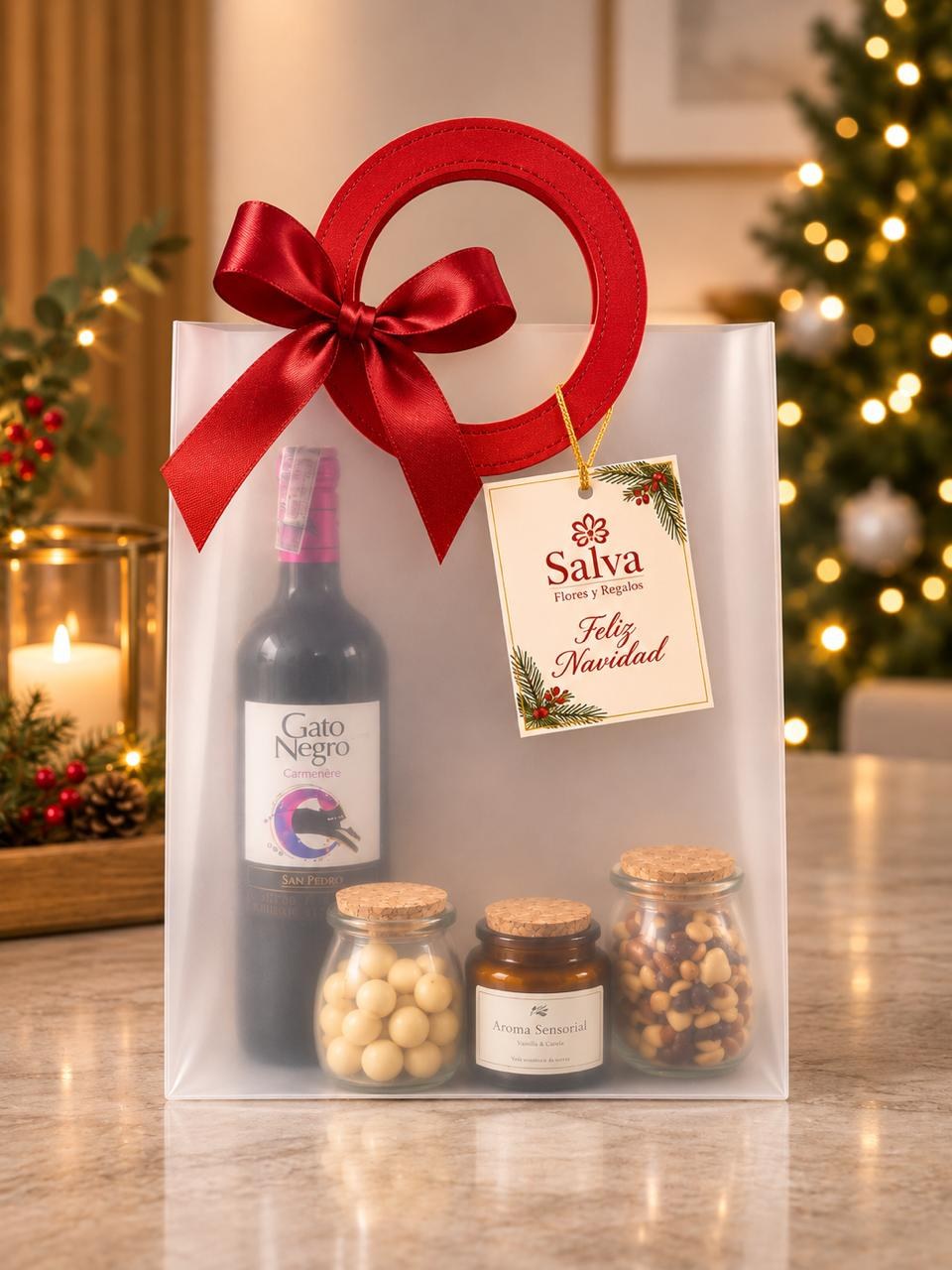 Ancheta de lujo navideña con vino tinto, vela aromática, macadamias y frutos secos en bolsa de regalo con moño rojo – Salva Flores y Regalos
