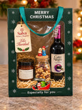 Ancheta navideña con vino tinto, vela aromática y frutos secos en caja de regalo Merry Christmas – Salva Flores y Regalos